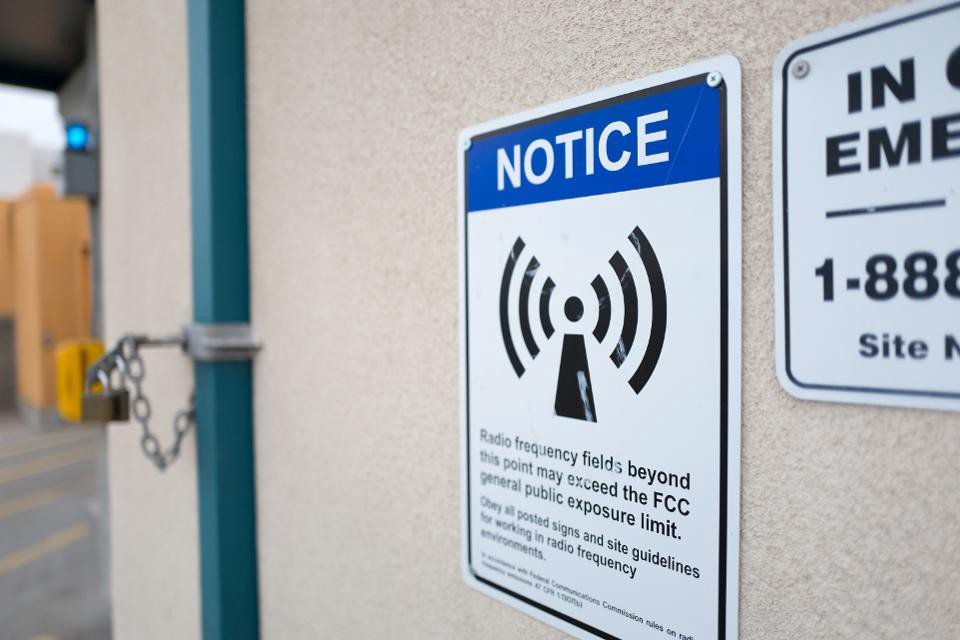 Warning sign on the side of a cellular phone tower indicating that the tower emits strong radio, magnetic and other radiation, and warning those near the tower to take protective measures. Only at incredibly close distances can this radiation even plausibly negatively affect humans.